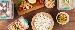 Cinq lunch boxes ouvertes contenant des portions de riz basmati prêtes à être emportées.
