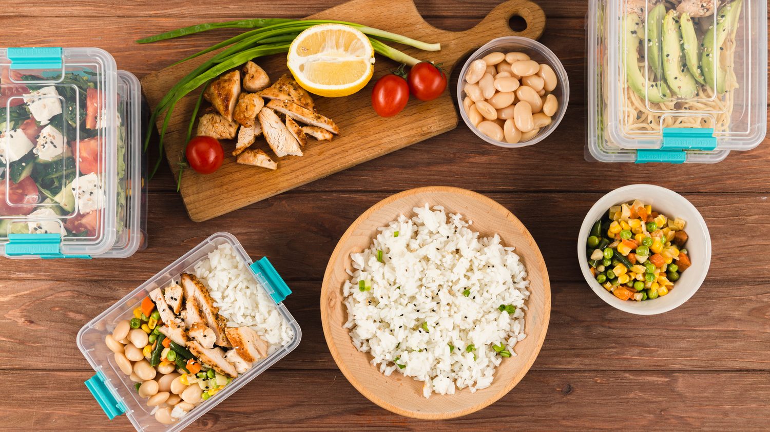 Cinq lunch boxes ouvertes contenant des portions de riz basmati prêtes à être emportées.