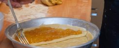 Une personne fouette une pâte à crêpes grumeleuse dans un saladier pour la lisser.