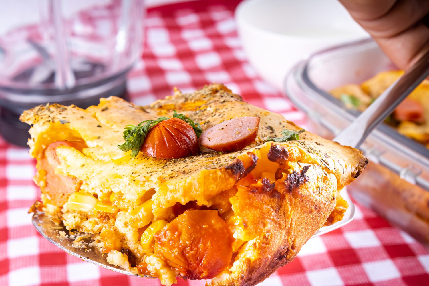 Gratin de pain au levain avec restes de tome et rondelles de saucisson, servi dans un plat à gratin.